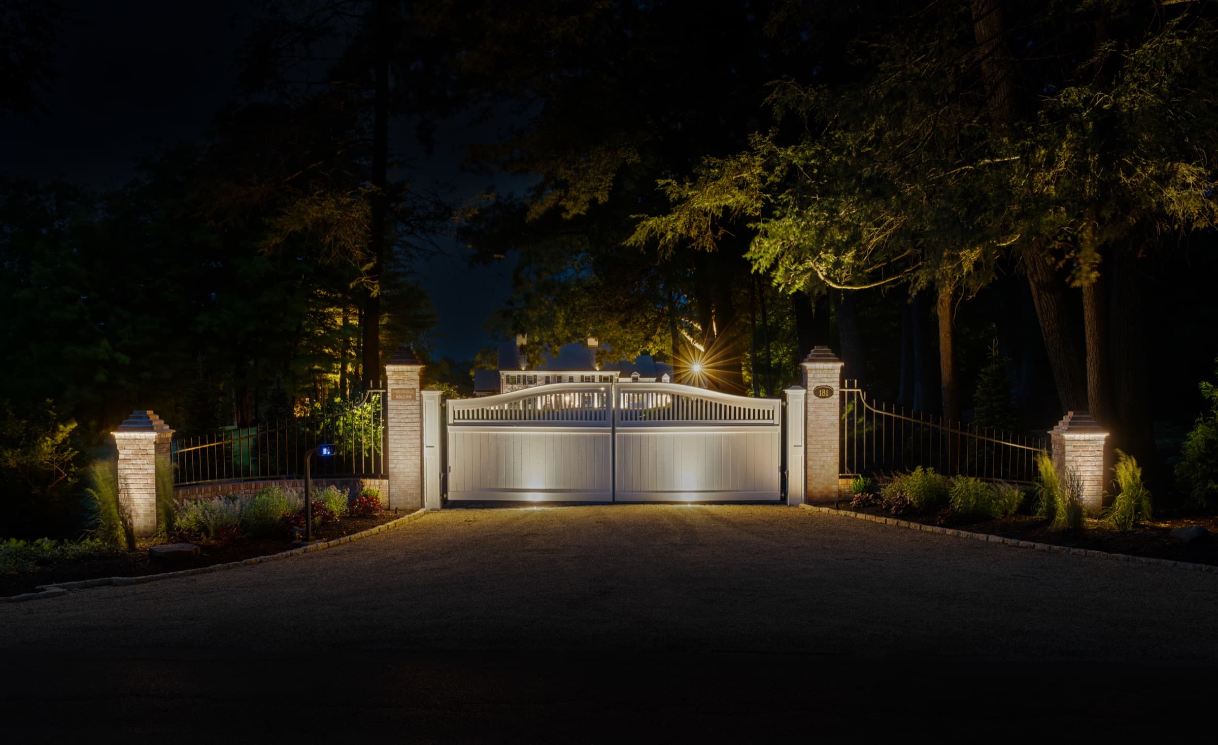 Lit gated entrance at the head of the drive